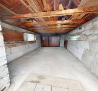 A garage of a family house with a concrete floor and a wooden ceiling.