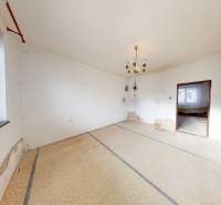 A room in a family house with white walls, simple windows, and light.