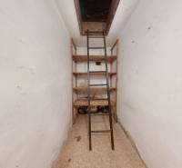 Narrow room with shelves and stairs to the attic in a family house.