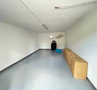 A garage in a family house with white walls and a concrete floor, stored tires.