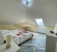 Attic bedroom in a family house with a bed, lamp, and skylight.