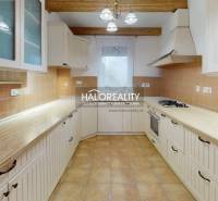 A kitchen in a family house with wooden elements, tiles, and built-in appliances.