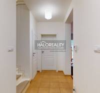 A hallway with tiles in a family house, entrance to the staircase and rooms.
