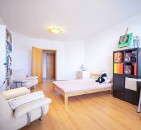 A bright room in a 3-room apartment with a wooden decor floor and cozy furniture.