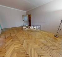 A spacious room with a wooden decor floor in a 3-room apartment, suitable for furnishing.