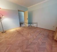 A room with a lamp, radiator, and wooden decor flooring in a three-room apartment.