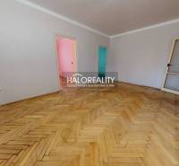 Living room with wood-patterned flooring in a three-room apartment.