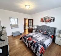 A bedroom in a 3-room apartment with London-themed decorations and a wood-patterned floor.