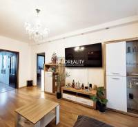 Living room in a 3-room apartment with a wooden decor floor and a crystal chandelier.