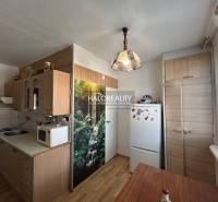 A kitchen unit with a wooden decor and a dining table in a 2-room apartment.