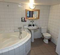 A bathroom in a family house with a bathtub, sink, and toilet. White tiles.