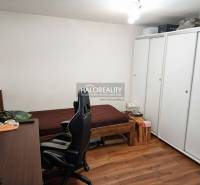 A room with a bed, a desk, a chair, and a floor with a wooden decor in a family house.