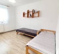 A bright room with two beds in a 3-room apartment, wooden decor flooring.