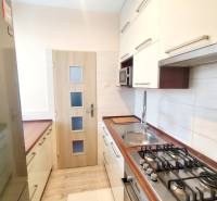 A kitchen in a 3-room apartment with wooden decor countertops and flooring.
