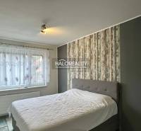 A bedroom with a large bed, wallpaper, and decorative flooring in a 3-room apartment.