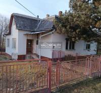 The picture shows an older family house with a front garden and an older fence.
