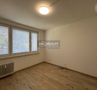 A room in a 3-room apartment with large windows and parquet flooring, unfurnished.