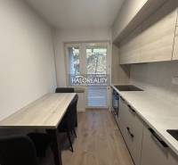 A kitchen in a 3-room apartment with a dining table and a floor with a wooden decor.