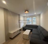 Living room with a dark sofa set, wooden decor flooring in a 3-room apartment.