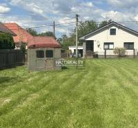 A garden with an older shelter, house in the background, ideal for residential plots.