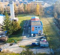Production facilities on Továrenská Street in Dubnica nad Váhom with adjacent parking and greenery.