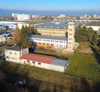 Production facilities on Továrenská Street in Dubnica nad Váhom, surrounded by greenery and buildings.