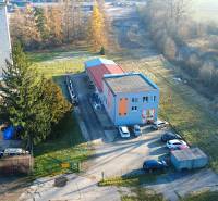 Production facilities on Továrenská Street in Dubnica nad Váhom surrounded by greenery and cars.