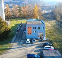 Production premises on Továrenská Street in Dubnica nad Váhom with a parking lot and greenery.