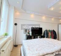 Bedroom in a 2-room apartment with a window and a television, floor with wooden decor.