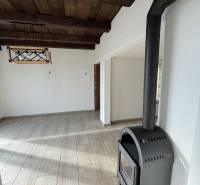 The wooden ceiling, wood-patterned floor, and fireplace in the cabin create a cozy atmosphere.