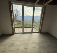 A cabin with a wooden floor decor, large window with a view of nature.