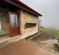 Entrance to the cabin in Šahy with stone cladding and paving.