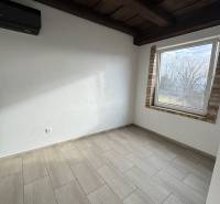 A room with a wooden ceiling, stove, and floor with a wooden decor in a cabin.