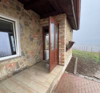Stone cottage in Šahy with a brick terrace and a view of nature.