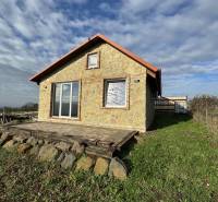 A cottage in Šahy with a stone facade, a terrace, and surroundings with natural stones.