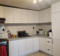 A kitchen in a family house with white cabinets, a stovetop, and a microwave.