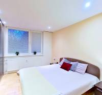 Bedroom in a 2-room apartment with a large bed, wardrobe, and floor with a wooden decor.