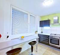 A kitchen with a gas stove and a bar counter in a 2-room apartment.