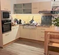 Kitchen of a 4-room apartment with a kitchen unit, appliances, and a wooden decor floor.