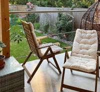 A terrace with garden seating and a green lawn in a 4-room apartment.