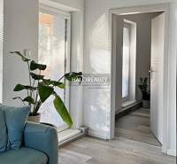 A bright living room with green plants and a wooden decor floor, 4-room apartment.