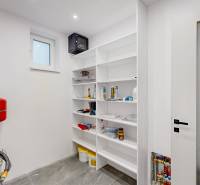Bathroom technical room with a boiler and shelving storage in a family house.
