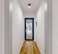 A narrow hallway in a family house with a wooden decor floor.