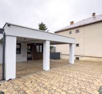 A family house in Nováčany with a large shelter and stone paving in the exterior.