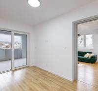 Interior of a family house with a balcony, wooden decor flooring, and a window with a view.