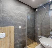 Bathroom in a family house with stone tiles and a shower enclosure.