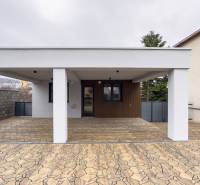 A family house in Nováčany with a white facade and a paved parking space.