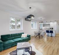 Living room in a family house with a sofa, dining table, and wooden decor flooring.