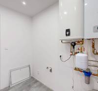 Technical room in a family house with a boiler and a red and white expansion tank.