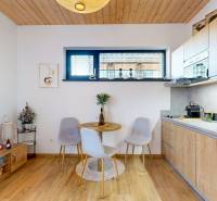 A kitchen in a holiday apartment with a wooden decor floor, table, and chairs.